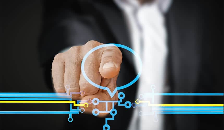 Person pointing at a digital speech bubble interface with circuit lines, wearing a dark suit.