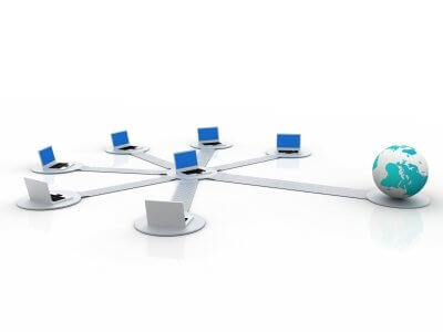 Network diagram with six computers connected by cables to a globe, symbolizing global connectivity.
