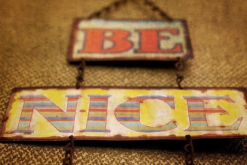 Rustic signs with the text "BE NICE" in bold, colorful letters.