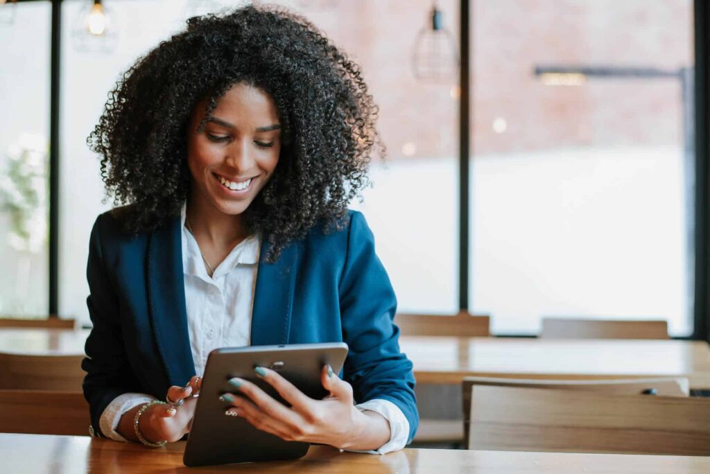 Women scrolling on a tablet in an office